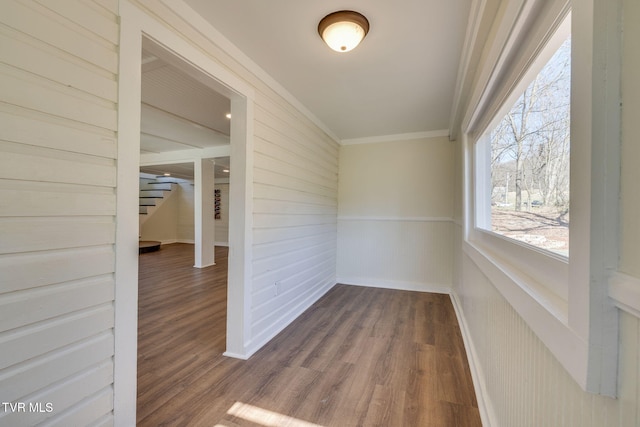 interior space with stairs, crown molding, wood finished floors, and wainscoting