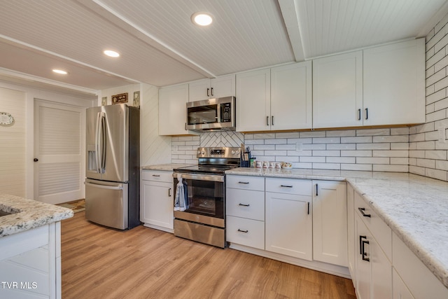 kitchen with light wood finished floors, white cabinets, and appliances with stainless steel finishes