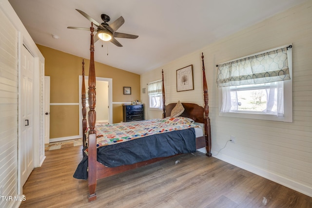 bedroom with vaulted ceiling, wood finished floors, baseboards, and ceiling fan