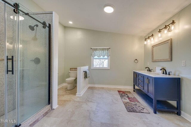 bathroom with a shower stall, baseboards, toilet, double vanity, and a sink