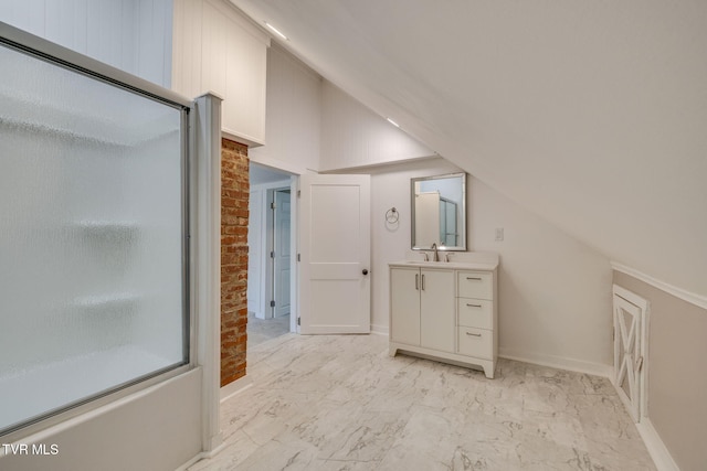 bathroom with a shower with shower door, marble finish floor, baseboards, vanity, and vaulted ceiling