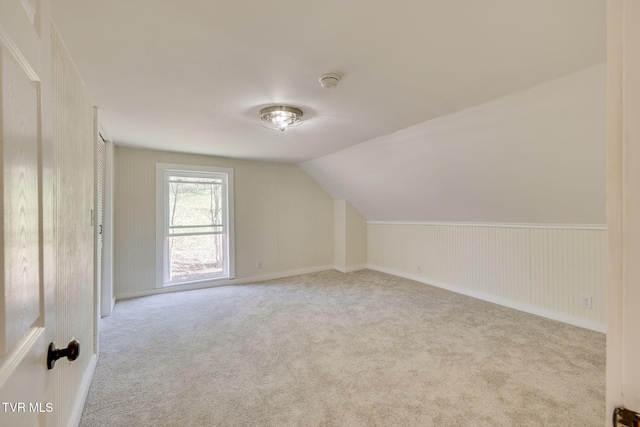 bonus room featuring vaulted ceiling and carpet