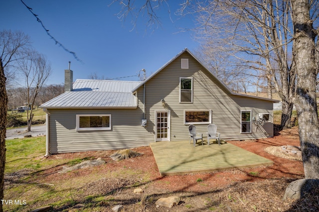 back of house with a patio area, a chimney, and metal roof