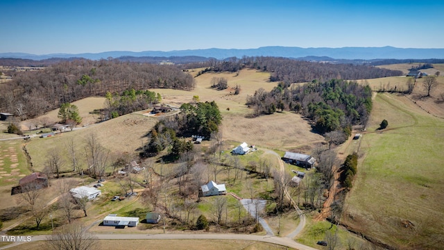 drone / aerial view with a wooded view and a mountain view