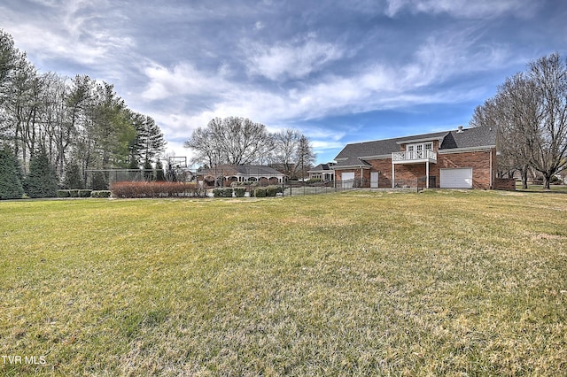 view of yard featuring an attached garage and fence