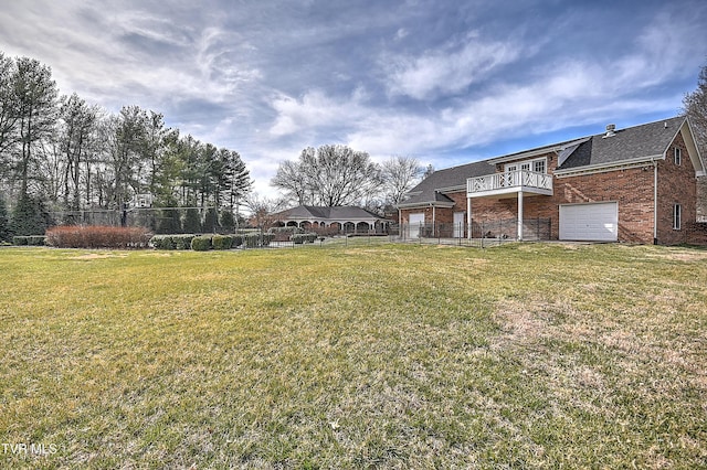 view of yard featuring an attached garage and fence