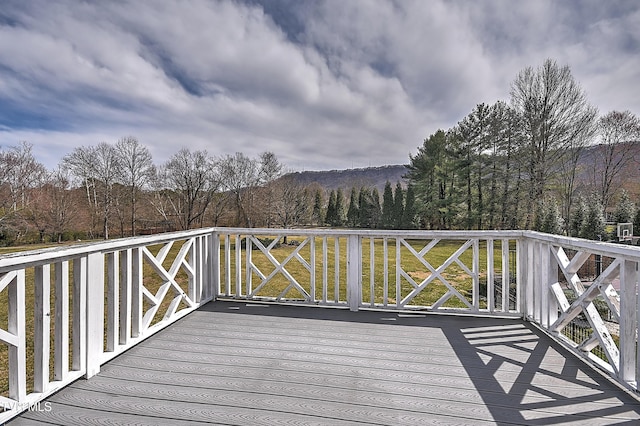 wooden deck featuring a lawn