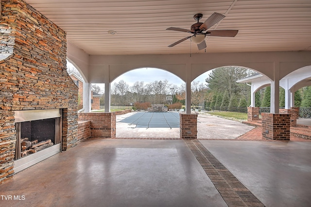 view of patio / terrace featuring a ceiling fan and an outdoor fireplace