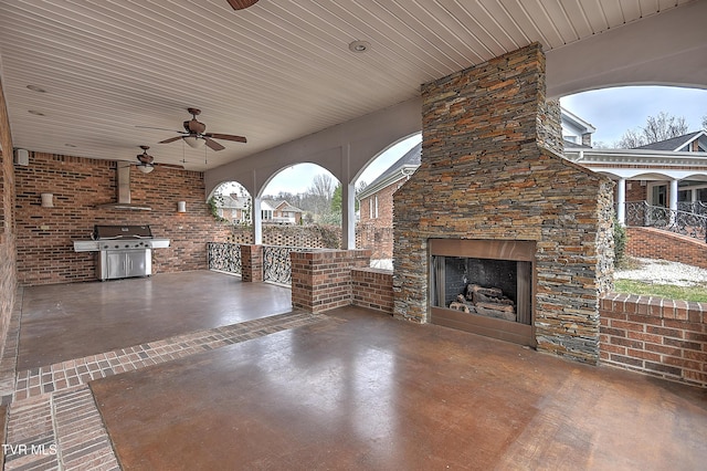 view of patio featuring grilling area, an outdoor stone fireplace, and ceiling fan