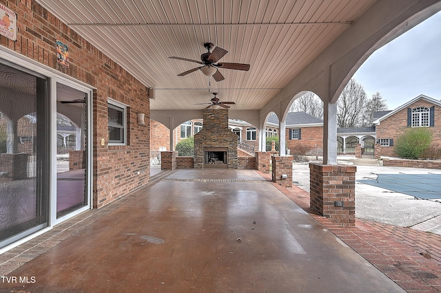 view of patio with an outdoor stone fireplace and ceiling fan