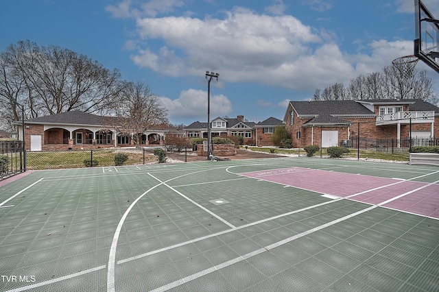 view of basketball court featuring a residential view, community basketball court, and fence