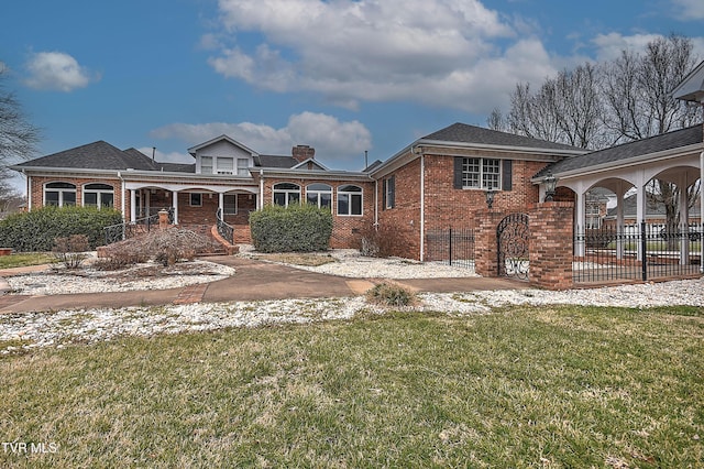 view of front of property featuring fence, covered porch, a chimney, a front lawn, and brick siding