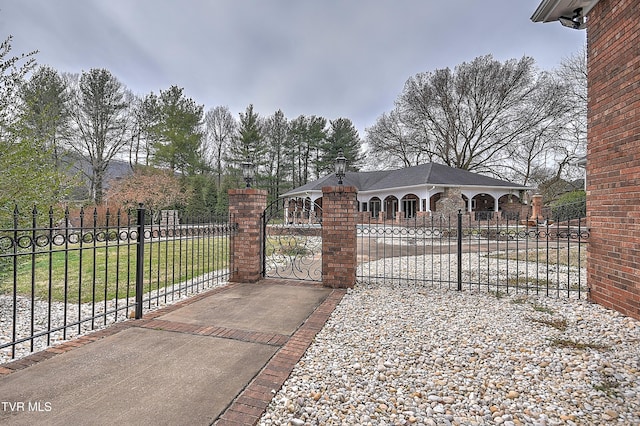 view of gate with a yard and fence