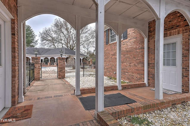 view of patio featuring covered porch and a gate