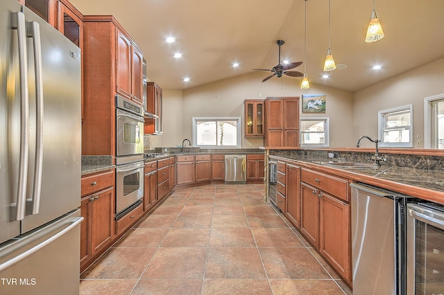 kitchen featuring beverage cooler, dark countertops, stainless steel appliances, brown cabinetry, and glass insert cabinets