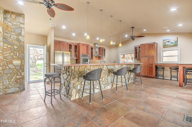 kitchen featuring brown cabinetry, appliances with stainless steel finishes, and ceiling fan