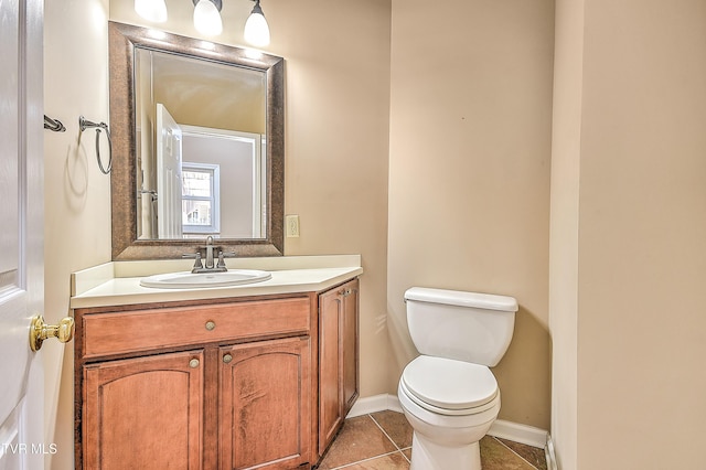 bathroom with tile patterned floors, baseboards, toilet, and vanity