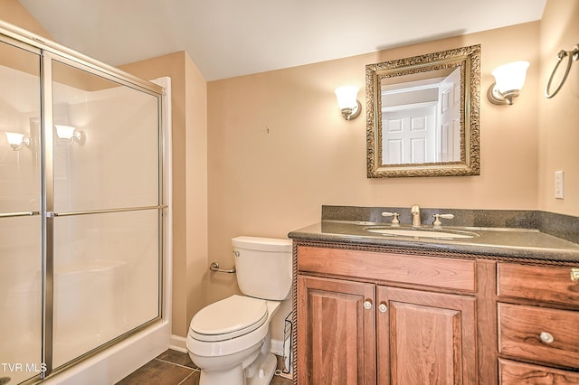 bathroom featuring toilet, a shower stall, tile patterned flooring, baseboards, and vanity