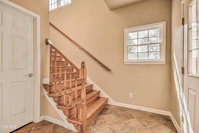 stairs with a wealth of natural light and baseboards