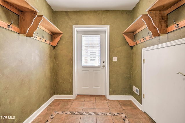 doorway featuring light tile patterned flooring, visible vents, and baseboards