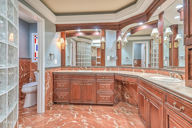 full bathroom featuring a sink, a wainscoted wall, toilet, and double vanity