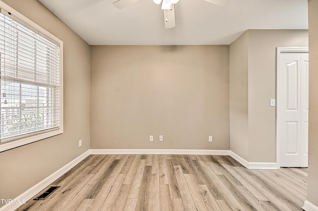 empty room featuring visible vents, baseboards, light wood-style flooring, and a ceiling fan