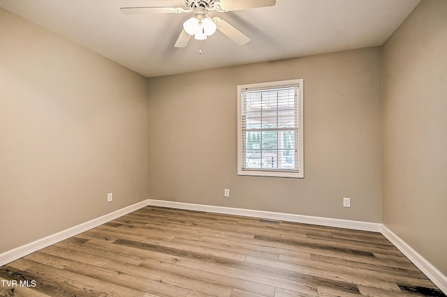 empty room with ceiling fan, visible vents, baseboards, and wood finished floors