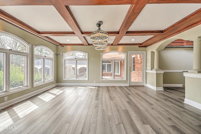 unfurnished living room featuring wood finished floors, visible vents, ornate columns, and baseboards