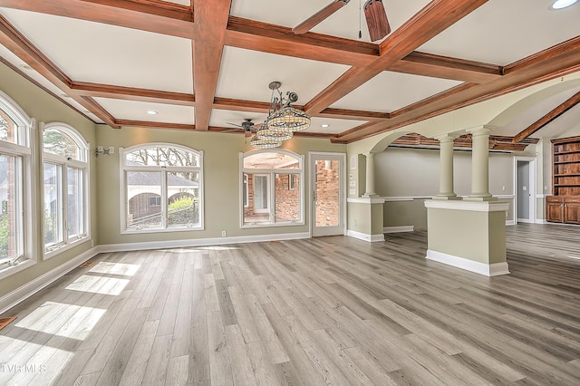 unfurnished living room featuring baseboards, wood finished floors, ceiling fan, and decorative columns