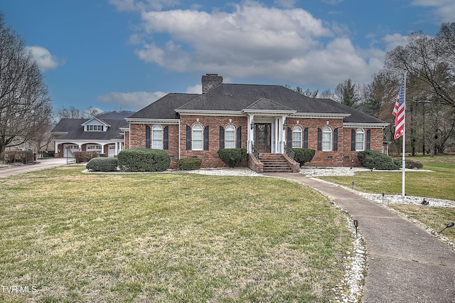 greek revival inspired property with brick siding, a chimney, and a front lawn