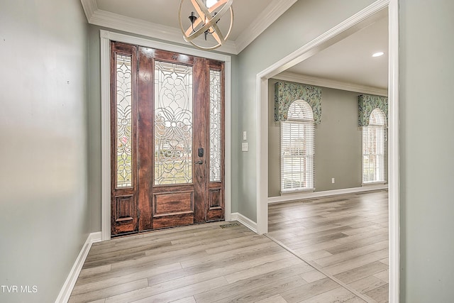 foyer featuring a chandelier, wood finished floors, baseboards, and ornamental molding