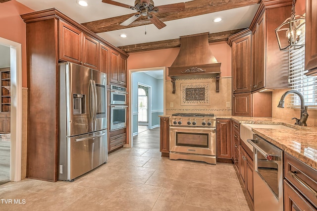 kitchen with light stone countertops, custom exhaust hood, a sink, stainless steel appliances, and beamed ceiling