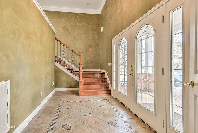 tiled entrance foyer with a healthy amount of sunlight, french doors, baseboards, and ornamental molding