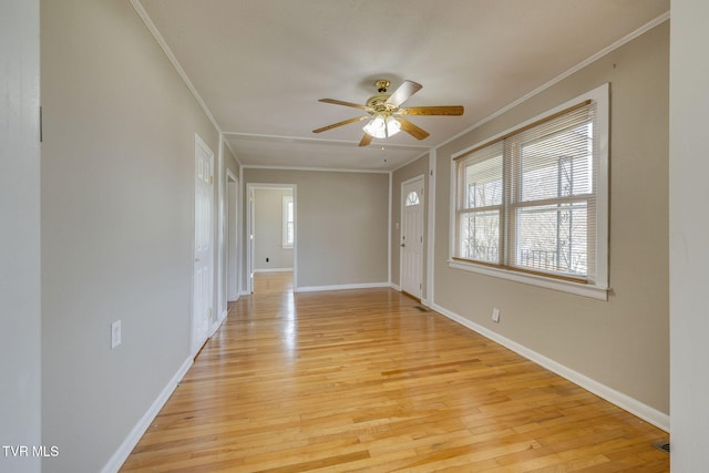 foyer entrance with light wood-style flooring, baseboards, ornamental molding, and a ceiling fan