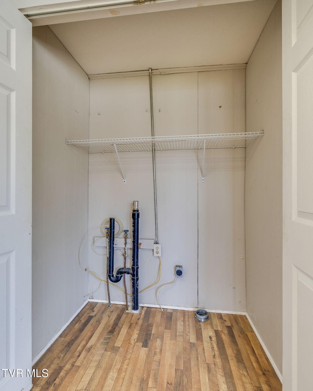 clothes washing area with laundry area and wood-type flooring