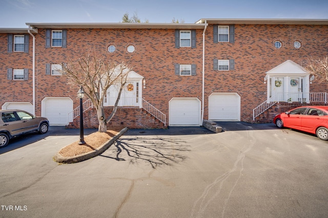 view of front of property with driveway, brick siding, and an attached garage