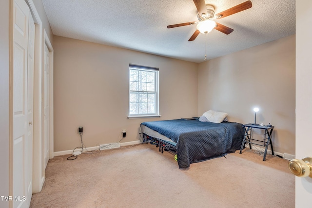 bedroom with carpet, baseboards, and a textured ceiling