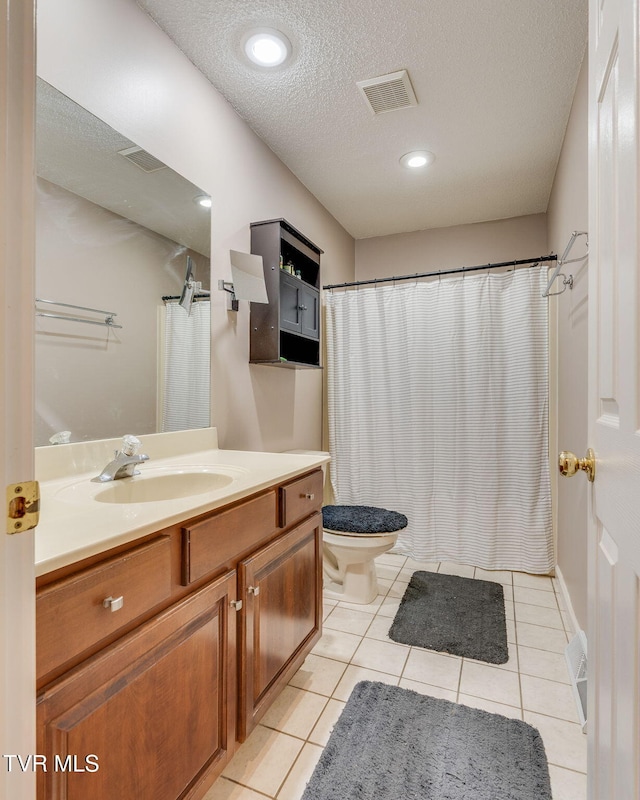 bathroom with vanity, visible vents, tile patterned flooring, a textured ceiling, and toilet