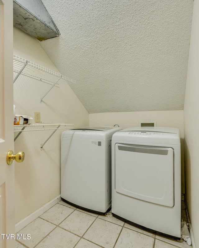 washroom with washer and dryer, baseboards, a textured ceiling, and laundry area