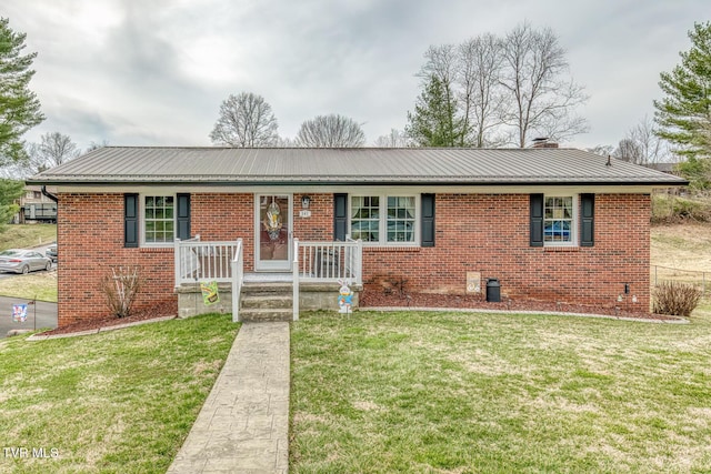 ranch-style house featuring a front yard, brick siding, and metal roof