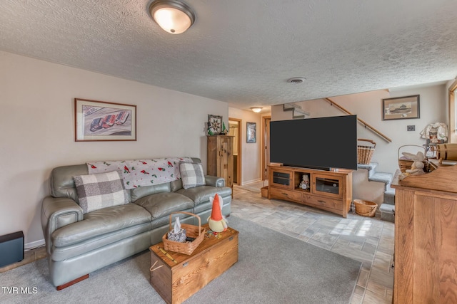 living area with visible vents, a textured ceiling, and baseboards