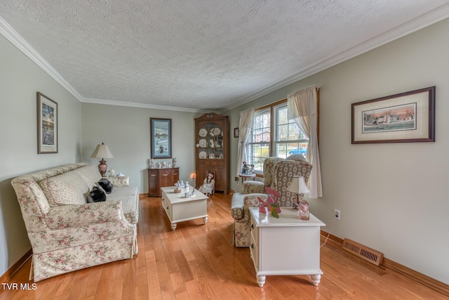 living room featuring crown molding, light wood-style flooring, baseboards, and visible vents