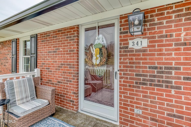 doorway to property with brick siding