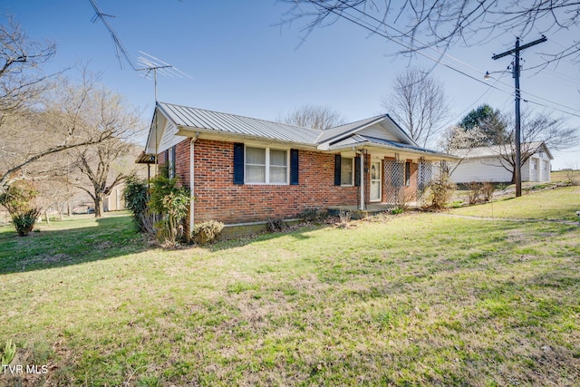 view of front of property featuring brick siding, a front lawn, covered porch, metal roof, and a standing seam roof