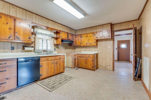 kitchen featuring dishwashing machine, light floors, light countertops, wood walls, and brown cabinets