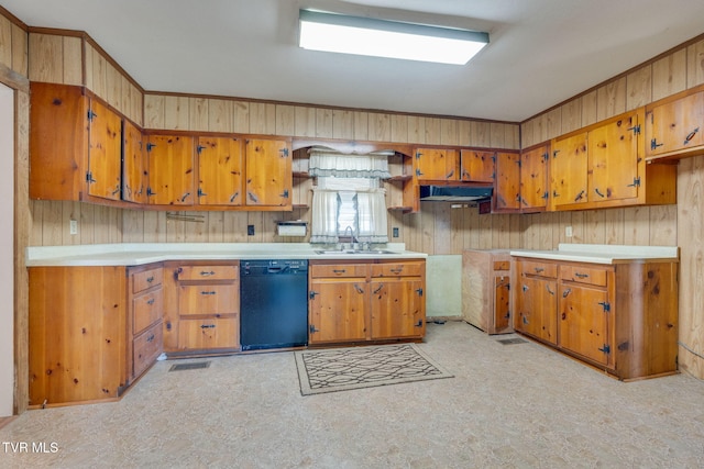 kitchen with under cabinet range hood, light floors, dishwasher, brown cabinetry, and a sink