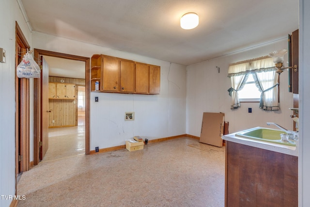 kitchen featuring a sink, baseboards, light floors, brown cabinetry, and open shelves