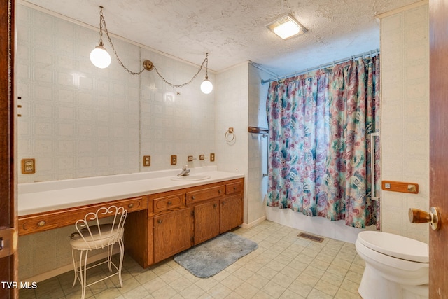 bathroom featuring vanity, visible vents, a textured ceiling, toilet, and shower / tub combo with curtain