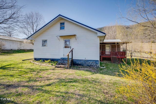 back of house with a lawn and entry steps