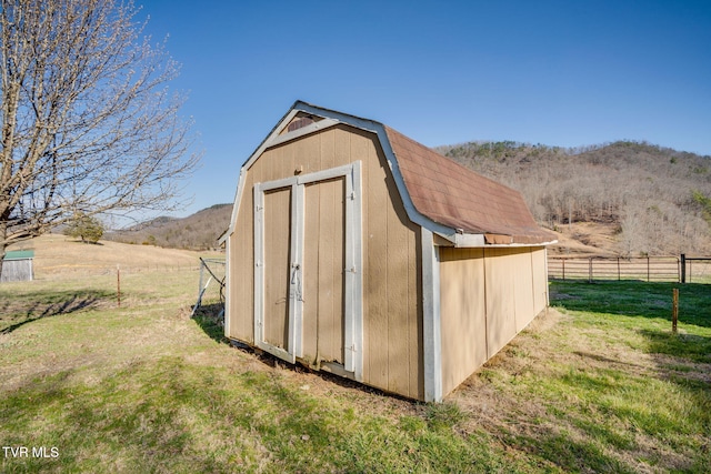 view of shed with a mountain view, a rural view, and fence